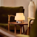 Pissarro Small marbre Calacatta Vionaro lampe de table rechargeable Tavellio – sur un plaid à motifs posé sur un canapé – abat-jour dôme opalin