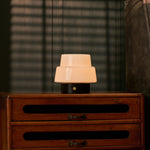 Oplaadbare tafellamp Pissarro Small Nero Marquina zwart marmer, op dressoir naast fauteuil
