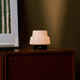 Oplaadbare tafellamp Pissarro Small met Nero Marquina zwart marmer, brandend op dressoir