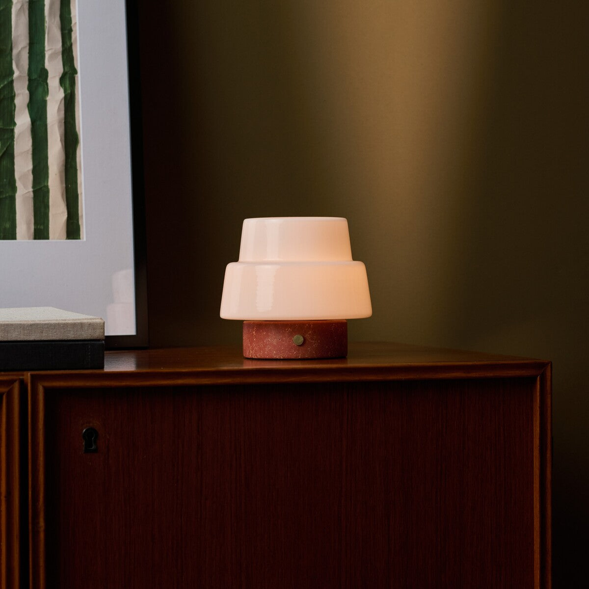 Tafellamp oplaadbaar Pissarro Small rood travertin gloeiend op een houten dressoir