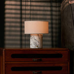 Redon cordless table lamp with arabescato marble base glowing on a wooden bedroom nightstand