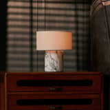 Redon cordless table lamp with arabescato marble base glowing on a wooden bedroom nightstand