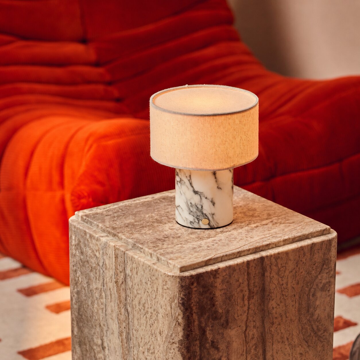 Redon rechargeable table lamp with white Arabescato marble base and cream shade on stone side table