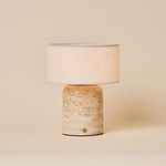 Redon rechargeable table lamp with textured beige travertine base and cream drum shade