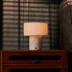 Redon rechargeable table lamp with rosa aurora marble base glowing on a bedroom nightstand