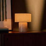 Redon rechargeable table lamp with rosa aurora marble base illuminated on a dark wood cabinet