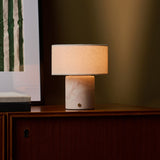 Redon cordless table lamp with pink rosa aurora marble base beside framed art on a sideboard
