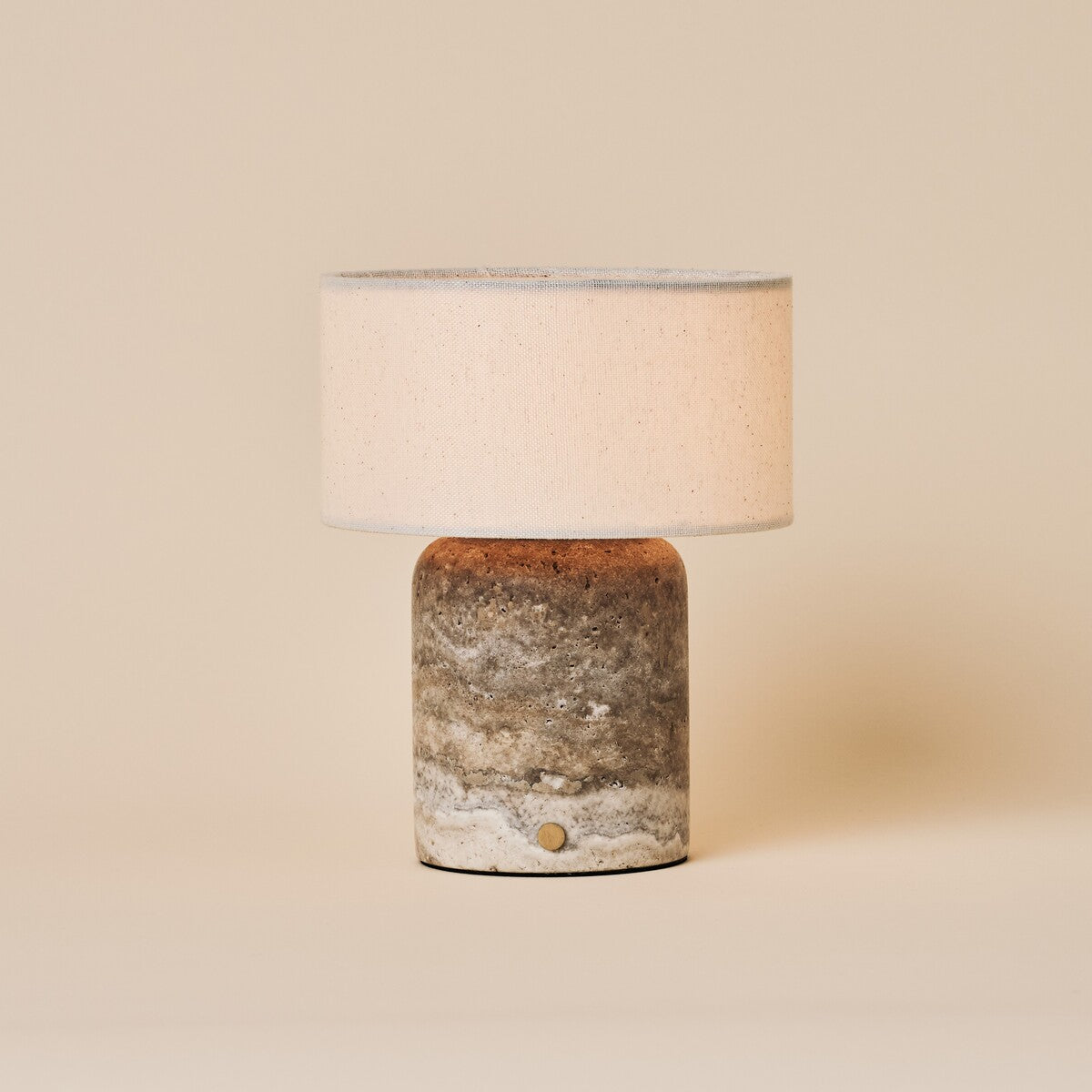 Redon cordless table lamp with silver-grey travertine base and beige linen drum shade