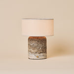 Redon cordless table lamp with silver-grey travertine base and beige linen drum shade