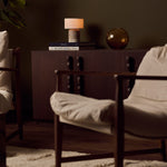 Redon rechargeable table lamp with silver travertine base on a stack of books in living room