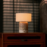 Redon rechargeable table lamp with silver travertine base glowing on wooden nightstand