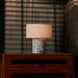 Rechargeable table lamp Redon with blue calcite marble base and ribbed opal glass shade on a red velvet sofa
