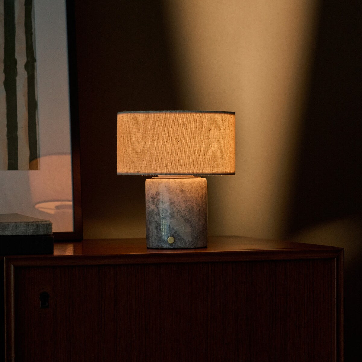 Redon cordless table lamp with blue-grey calcite marble base and beige linen shade on wooden sideboard