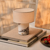 Rechargeable table lamp Redon with grey-veined marble base and ribbed opal glass shade on a wood cabinet