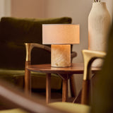 Redon rechargeable table lamp with honey onyx marble base and linen drum shade on a wooden side table