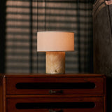 Redon rechargeable table lamp with honey onyx marble base glowing on a wooden bedroom nightstand