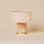 Redon cordless table lamp featuring an amber onyx marble base and beige linen drum shade
