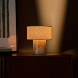 Redon cordless table lamp with amber onyx marble base illuminated on a dark wood sideboard