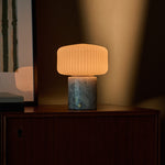 Rechargeable table lamp with Blue Calcite marble base glowing on a wooden dresser at night