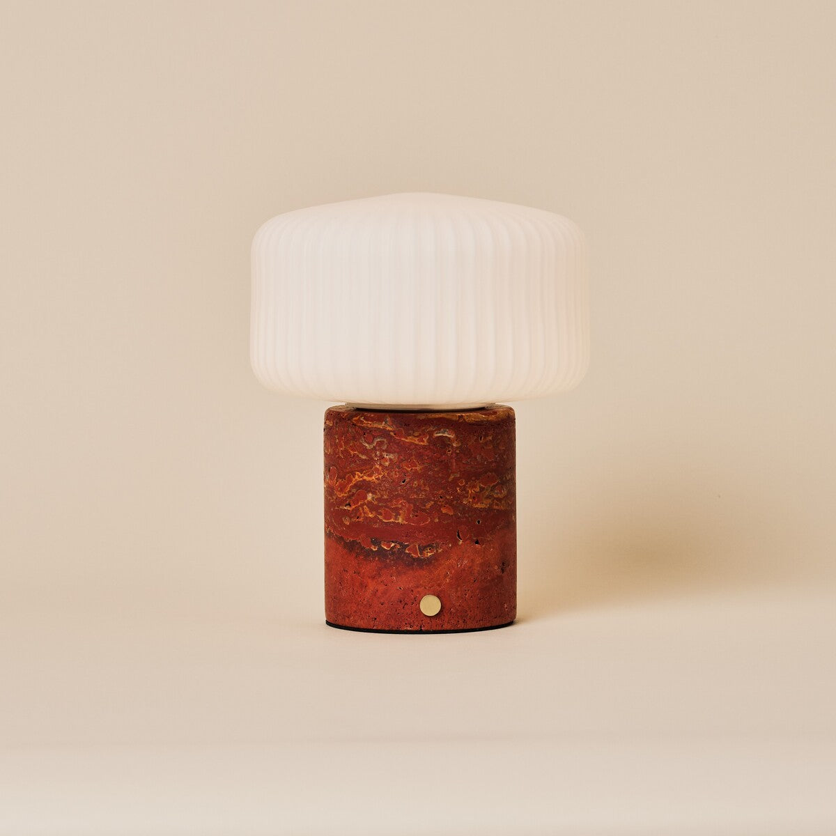 Rechargeable table lamp Renoir red travertine base with fluted white glass shade, studio shot