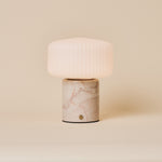 Renoir Medium cordless table lamp in rosa aurora marble with ribbed glass shade, studio shot
