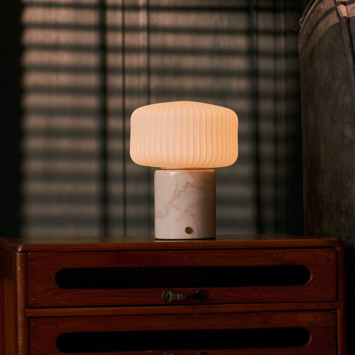 Renoir Medium rechargeable table lamp with rosa aurora marble base on a bedside dresser
