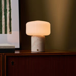 Renoir Medium rechargeable table lamp with rosa aurora marble base on a dark wood sideboard