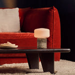 Cordless Renoir table lamp in silver travertine with a fluted glass shade on a stone block
