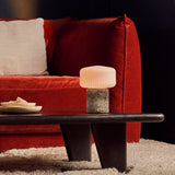 Cordless Renoir table lamp in silver travertine with a fluted glass shade on a stone block