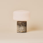 Rechargeable Renoir table lamp in silver travertine with a ribbed glass shade