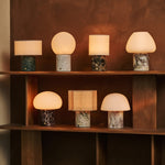 Tavellio Rijks Collection rechargeable table lamps in mixed marble finishes on a wooden shelf
