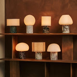 Tavellio Rijks Collection rechargeable table lamps in mixed marble finishes on a wooden shelf