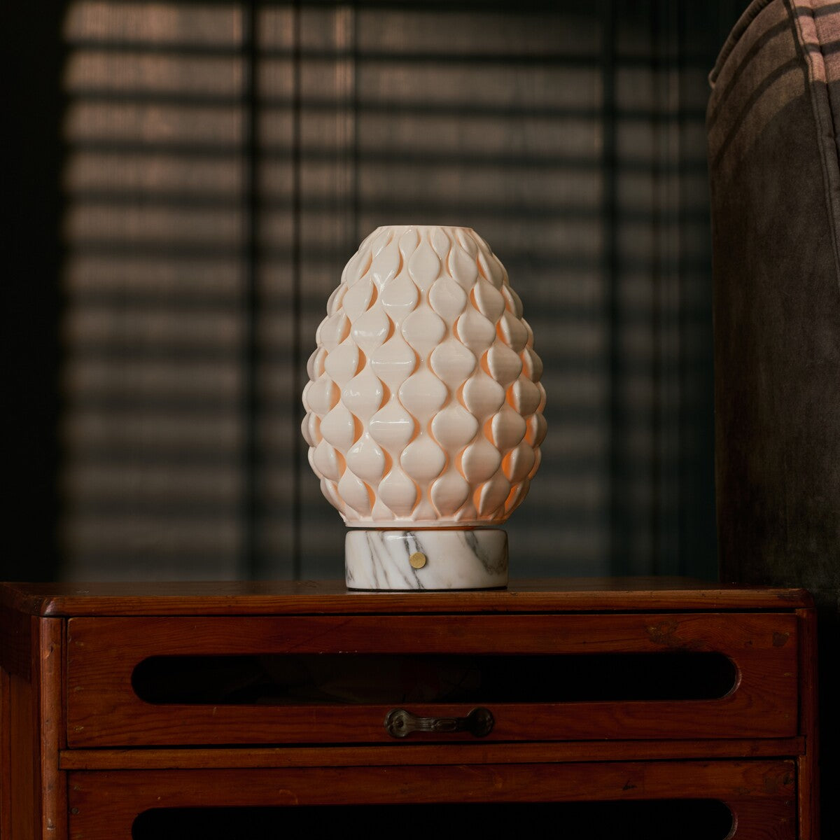 Cordless table lamp Serena Arabescato marble, glowing porcelain shade on vintage wooden dresser