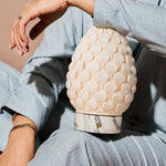 Rechargeable table lamp Serena Arabescato marble, textured porcelain shade held close in hand