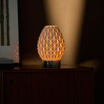 Serena cordless table lamp with Calacatta Viola marble base casting warm light near framed art