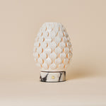 Serena rechargeable table lamp, white porcelain petal shade on white marble base, studio shot