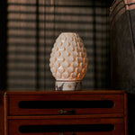 Serena rechargeable table lamp lit on bedside table, white marble base, moody interior scene