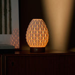 Serena cordless table lamp with chestnut porcelain base and beige linen shade on wooden side table
