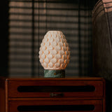 Rechargeable table lamp Serena Ice Green marble, glowing porcelain shade on wooden bedside cabinet