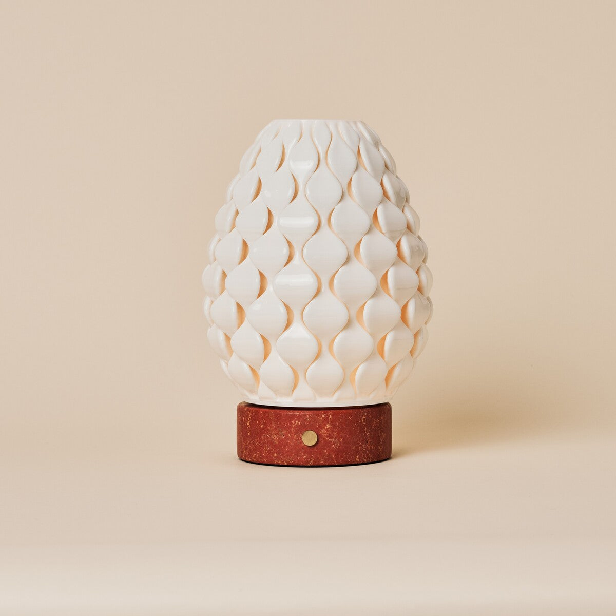 Cordless table lamp Serena in red travertine with scalloped porcelain shade, studio shot