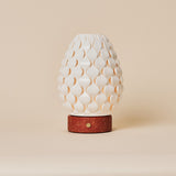 Cordless table lamp Serena in red travertine with scalloped porcelain shade, studio shot