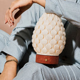 Rechargeable table lamp Serena red travertine porcelain shade held against blue clothing