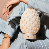 Rechargeable table lamp Serena Rosa Aurora marble, textured porcelain shade held close-up in hand