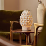 Cordless table lamp Serena Rosa Aurora marble, cream porcelain shade beside vase on wooden table