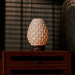 Serena Rosso Levanto rechargeable table lamp lit beside framed art on a dark wooden sideboard