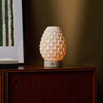 Rechargeable table lamp Serena silver travertine porcelain shade beside framed green wall art