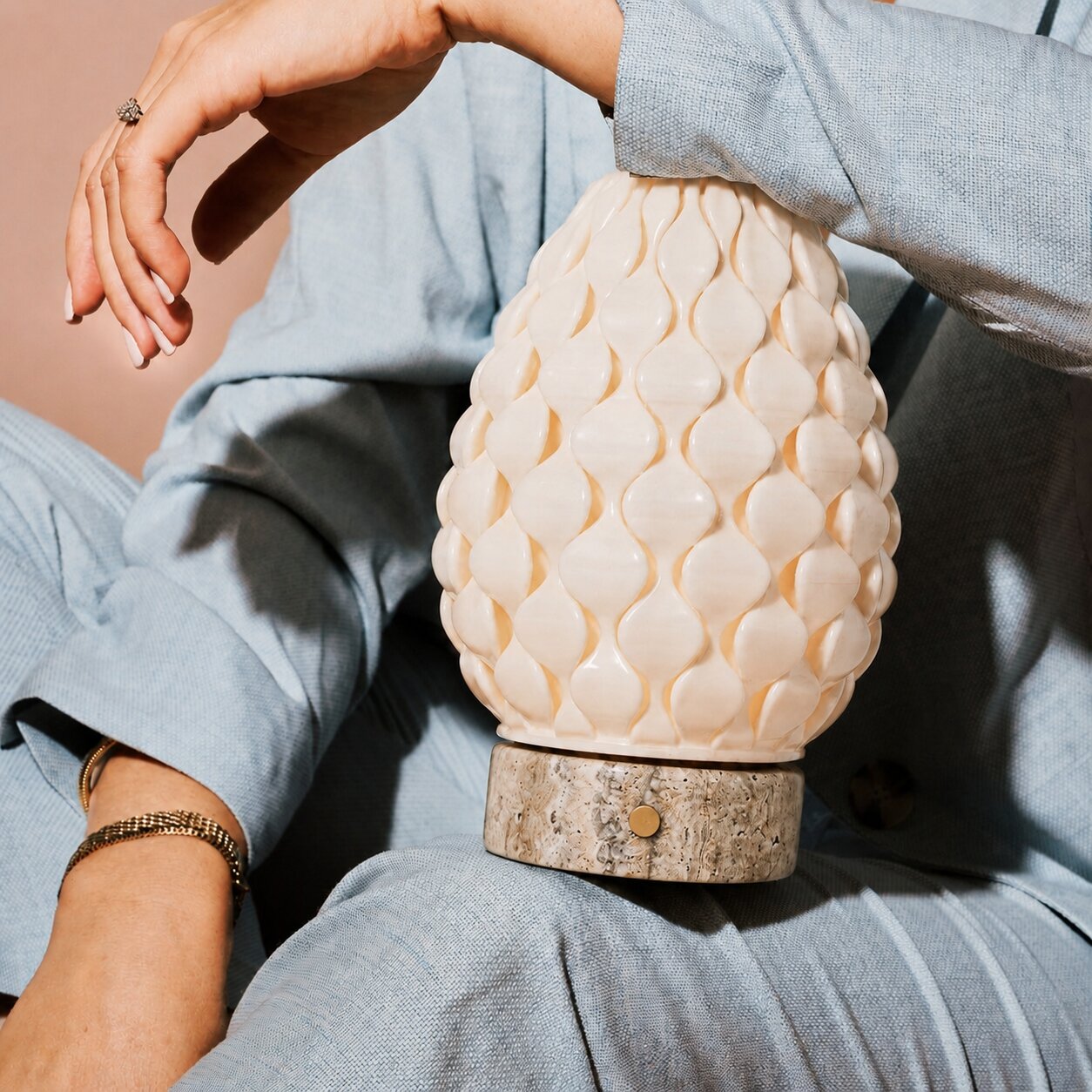 Rechargeable table lamp Serena silver travertine porcelain shade held in hand, close-up detail