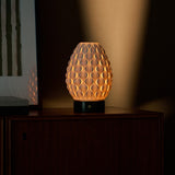 Serena Verde Alpi rechargeable table lamp lit beside framed bamboo art on a dark wooden sideboard