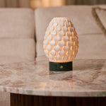 Serena Verde Alpi marble rechargeable table lamp glowing on a marble side table beside a cream sofa