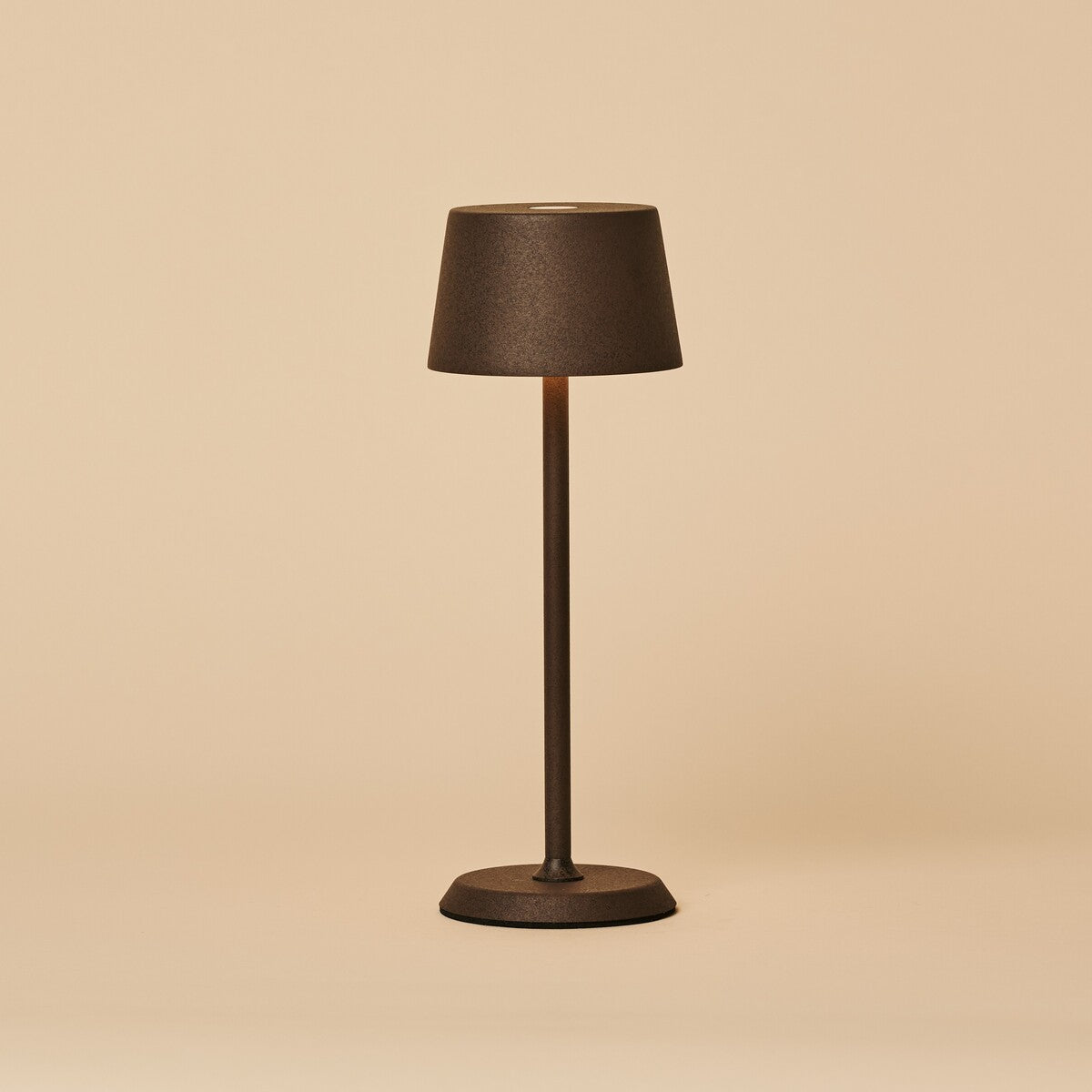 Lampe de table sans fil rechargeable Tavellio Brouwer Mini Mocha en métal texturé, vue de face sur fond neutre, allumée.